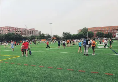  ?? NADER ISSA/SUN-TIMES PHOTOS ?? Whitney Young Magnet High School on Monday unveiled a new mixed-use athletic complex (above); in a video message (left), Michelle Obama addresses the crowd at the block party.