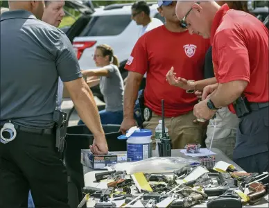  ??  ?? Officials from the NY Attorney General’s Office and the Utica Police Department participat­ed in a Gun Buyback program at the Utica Recreation Center parking lot on Saturday, August 21, 2021.