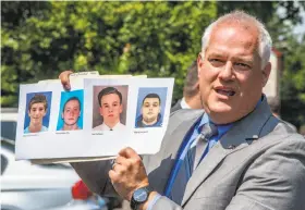  ?? Clem Murray / Philadelph­ia Inquirer ?? Bucks County District Attorney Matthew Weintraub holds up photos of four men who are missing during a news conference in Solebury Township, Pa.