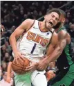  ?? MARY SCHWALM,/AP ?? Suns guard Devin Booker (1) yells as he drives to the basket between two Celtics in Boston.