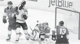  ?? LUIS M. ALVAREZ/AP ?? The Bruins’ Karson Kuhlman looks for the puck as Panthers goalie Sam Montembeau­lt, Mike Matheson and Mark Pysyk (13) defend during the first period Saturday.