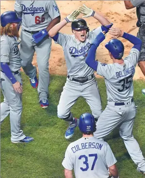  ?? JOHN STARKS / DAILY HERALD VIA AP ?? Los Angeles Dodgers’ Enrique Hernandez (center) celebrates his grand slam against the Chicago Cubs in Game 5 of the National League Championsh­ip Series on Thursday at Wrigley Field in Chicago. The Dodgers won 11-1 to reach the World Series.