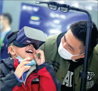  ?? ZHAI HUIYONG / FOR CHINA DAILY ?? A child watches cloud video footage using virtual reality technology at the Light of Internet Expo, part of the World Internet Conference — Internet Developmen­t Forum, in Wuzhen, Zhejiang province, on Sunday.