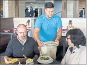  ?? STEPHEN B. MORTON — THE WASHINGTON POST ?? Server Gustavo Salines delivers meals to customers at Skull Creek Dockside Waterfront Restaurant on Hilton Head Island, S.C. Staffing at the restaurant is down 10 percent because of a labor shortage.