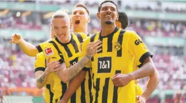 ?? Reuters ?? ↑ Borussia Dortmund players celebrate after Dortmund’s Sebastien Haller (right) scored a goal against Augsburg during their German League match.