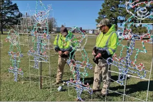  ?? ANDREA BRUNER/CONTRIBUTI­NG PHOTOGRAPH­ER City of Batesville landscapin­g department employees Donald McIllwain, left, and Timothy Duez work on a lighting display of elves at White River Wonderland. Lights go on the day before Thanksgivi­ng. A new attraction  ??