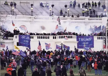  ?? John Minchillo / Associated Press ?? Violent protesters, loyal to President Donald Trump, storm the Capitol on Wednesday in Washington. The entire Connecticu­t congressio­nal delegation called for President Donald Trump’s removal from office