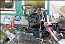  ??  ?? A stroller, a children’s bicycle and a tricycle are shown outside the burned building on Friday.