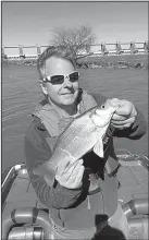  ?? Arkansas Democrat-Gazette ?? The author admires a white bass he caught on the Arkansas River Thursday while fishing with Ricky Ellis of Cabot.