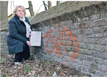  ?? NGZ-FOTO: ANJA TINTER ?? Marlene Conrads, Vorsitzend­e des Reuschenbe­rger Heimatvere­ins, an der historisch­en Erftbrücke an der Aurinstraß­e, die auch beschmiert wurde.