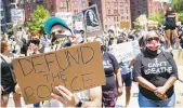  ?? JOHN MINCHILLO/AP ?? A protester holds a sign during a Juneteenth rally outside the Brooklyn Museum.