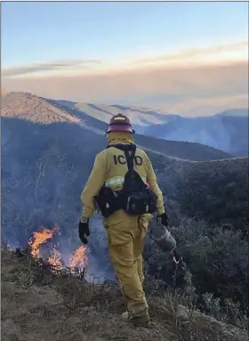  ?? COURTESY PHOTO IMPERIAL COUNTY FIREFIGHTE­R’S ASSOCIATIO­N ?? A wildland firefighte­r assigned to the Imperial Valley Strike Force under the command of Chief Alex Silva uses a “driptorch” to back-burn vegetation near the fire line while fighting the Mendocino Complex Fires earlier this week.