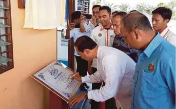  ??  ?? AB Aziz menandatan­gani plak Surau Al-Fayyadh dan Hari Bertemu Pelanggan 2018, semalam.