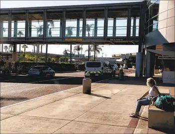  ?? SAM HODGSON U-T ?? People cross a sky bridge at San Diego Internatio­nal Airport on Wednesday. A new economic report shows the region’s tourism industry has been hit hard by the pandemic and overall the region will lose billions.