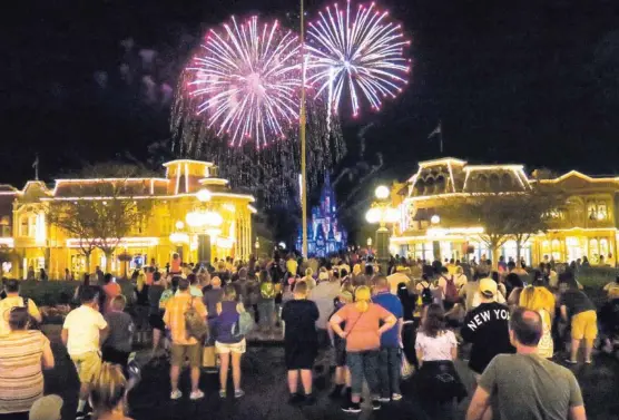  ?? JOE BURBANK/ORLANDO SENTINEL. ?? Los turistas se reúnen en Main Street de Magic Kingdom, el principal parque de Walt Disney World, el domingo pasado. Estos fueron los minutos finales antes del cierre del parque el domingo 15 de marzo de 2020 en Lake Buena Vista, Florida.