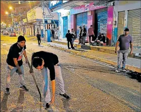  ??  ?? Una a una eran recogidas las piedras y pedazos de vidrios que fueron lanzados por los vándalos.