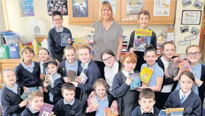  ??  ?? Swap shop Val Lightbody with school pupils at Chapelton Primary’s book exchange