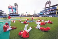  ?? MATT ROURKE/AP FILE ?? Philadelph­ia Phillies players loosen up before a game in 2017. Five Phillies have tested positive for COVID-19.