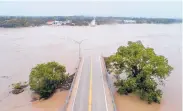  ?? JAY JANNER/AUSTIN AMERICAN-STATESMAN ?? The Llano River flows between the washed-out Ranch Road 2900 bridge on Tuesday in Kingsland, Texas.