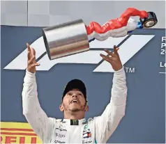  ??  ?? EL BRITÁNICO festeja con su trofeo en el podio