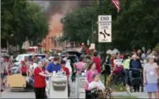  ?? AMBER ARNOLD — WISCONSIN STATE JOURNAL VIA AP ?? People evacuate as they were told to move farther away from the scene of an explosion in downtown Sun Prairie, Wis., Tuesday. The explosion rocked the downtown area of Sun Prairie, a suburb of Madison, after a contractor struck a natural gas main...