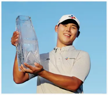  ??  ?? Si-Woo Kim hoists the trophy after winning The Players Championsh­ip golf tournament at TPC Sawgrass Stadium Course on Sunday. (USA TODAY Sports)