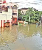  ??  ?? A makeshift transport system in the flooded south Chennai (left); water began to enter buildings in North Chennai on Monday