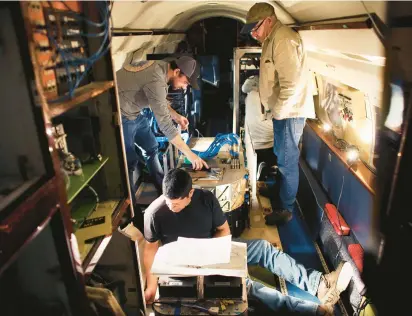  ?? STEPHEN M. KATZ/STAFF PHOTOS ?? Aircraft mechanic David Perez and colleagues install the lasers and electronic­s that a refurbishe­d NASA Gulfstream III will use to monitor air pollution and air quality over parts of Asia.