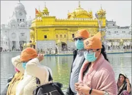  ?? SAMEER SEHGAL/HT ?? Visitors wearing face masks as a precaution­ary measure against coronaviru­s during a visit to the Golden Temple in Amritsar on Friday. n