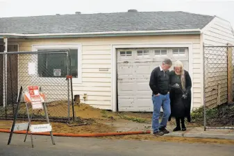  ?? Santiago Mejia / The Chronicle ?? Former homeowners Melissa McConnell (right) and husband Tom Wilson walk away from their old house moments before the excavator arrives to demolish it.