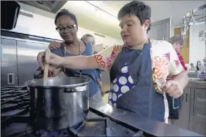  ??  ?? Program coordinato­r Marisa Baggett (left) helps Melissa Parham stir a pot of chili at The Exceptiona­l Foundation kitchen. “We fulfill the needs of adults that wouldn’t have anywhere to go if not for us,” says Baggett, who is also a sushi chef and...