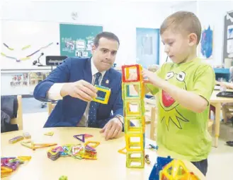  ?? RYAN TAPLIN ?? Education Minister Zach Churchill builds a tower with pre-primary student Camren Bond at Colby Village Elementary School on April 10.