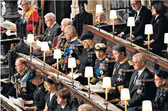  ?? ?? A family reflects The King, Queen Consort, Princess Royal and members of the Royal family during the service in St George’s Chapel, right