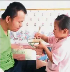  ?? — Photo taken from Kuaishou ?? Papa dearest: Tian’s daughter feeding him a meal.