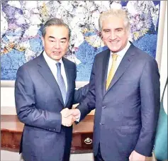  ?? — Reuters photo ?? Qureshi (right) shakes hand with Wang Yi at the Ministry of Foreign Affairs in Islamabad.