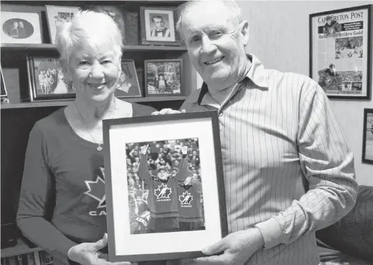  ?? JEREMY FRASER • SALTWIRE NETWORK ?? Matt and Kay Batherson hold a picture of their grandson Drake Batherson following his gold medal victory at the 2018 IIHF World Junior Hockey Championsh­ip in Buffalo, N.Y. Matt and Kay watched the first week of the tournament on television before arriving in Buffalo for the playoff round.