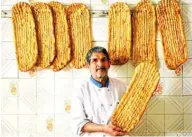  ??  ?? Iranian baker Esmail Asghari, 66, poses with Barbari bread in Tehran.