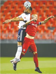  ?? VAUGHN RIDLEY/GETTY IMAGES ?? Toronto FC’s Michael Bradley battles for a header with the Caps’ Lucas Cavallini during the Reds’ 3-0 win at BMO Field on Tuesday. The teams face off again tonight in Toronto.