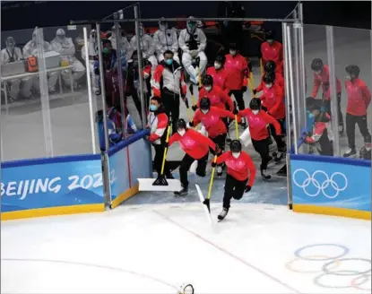  ?? LI ZIHENG / XINHUA ?? In the ice hockey field of the National Gymnasium, the “Snow Boys” of the clearing team rush onto the field between games to clean the ice.