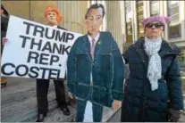  ?? PETE BANNAN – DIGITAL FIRST MEDIA ?? Dean Miller of Collegevil­le wears a Donald Trump mask while Sandy Malamed of West Vincent carries a Ryan Costello cutout at a tax bill protest on the steps of the Historic Chester County Courthouse to urge U.S. Rep. Costello, R-6, to vote ‘no’ on the...