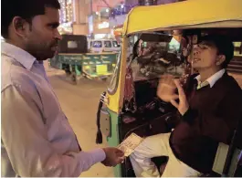  ??  ?? A taxi driver refuses to take a 500 rupee note from a passenger in New Delhi. This is part of a move to fight black market currency, corruption and counterfei­t notes in India.