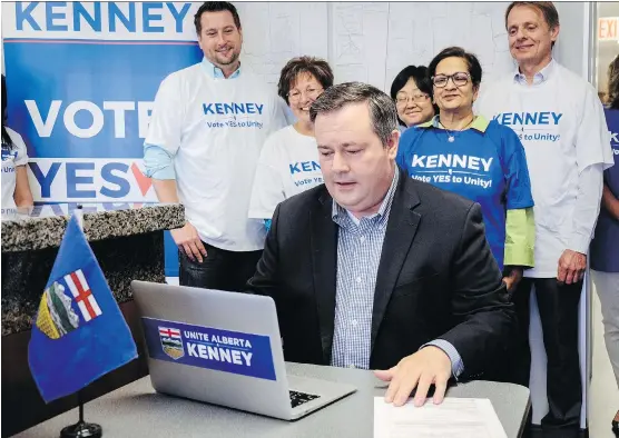  ?? JEFF MCINTOSH/ THE CANADIAN PRESS ?? Alberta PC Leader Jason Kenney, centre, cast his ballot in the PC Referendum on Unity at his campaign office in Calgary Thursday.