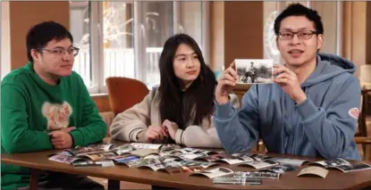  ?? PROVIDED TO CHINA DAILY ?? Three siblings from Taiwan, Lin Yen-chen (left), Lin Pei-ying (middle) and Lin Kuan-ting, show a photo of their late grandfathe­r Lin Wen-fang, at Peking University in Beijing.