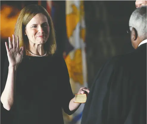  ?? Tom Brenner / reuters ?? Judge Amy Coney Barrett holds her hand on the Holy Bible at the White House on Monday as she is sworn in as an
associate justice of the U. S. Supreme Court by Supreme Court Justice Clarence Thomas.