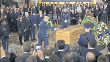  ?? J. SCOTT APPLEWHITE — THE ASSOCIATED PRESS ?? President Donald Trump touches the casket of the Rev. Billy Graham, who died last week at age 99, during a ceremony Wednesday in the Capitol Rotunda, where he will lie in honor as a tribute to America’s most famous evangelist. The president is joined...