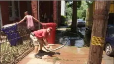  ?? EVAN BRANDT — MEDIANEWS GROUP ?? Landlord Vito Satiro uses the water being pumped out of the basement of 12 Walnut St. to rinse off the sidewalk outside the home.