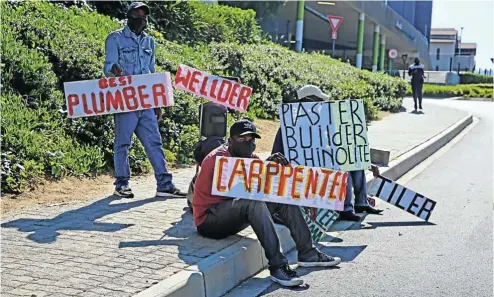  ?? Picture: Thapelo Morebudi ?? A group of unemployed men seen with signage advertisin­g their skills as they try to get jobs.