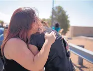  ??  ?? Annabel Hebben comforts her 11-year-old daughter, Leilani, on Sunday after placing flowers at a makeshift memorial near the site of the mass shooting Saturday morning in El Paso.