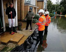  ?? REUTERS ?? Waterlogge­d: Flooded residents in Hemel Hempstead talk to utility workers