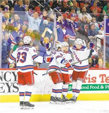  ?? GETTY ?? Rangers celebrate third-period goal as they delay Hurricanes’ playoff-clinching celebratio­n Thursday.